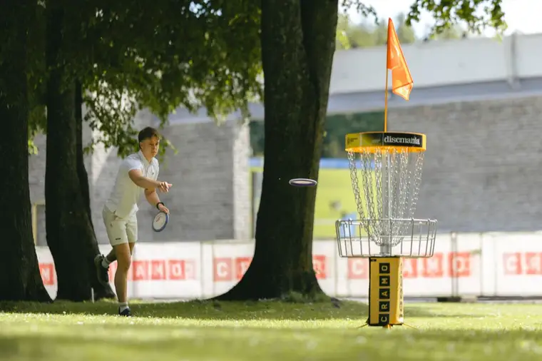 A player throwing at the basket on the course