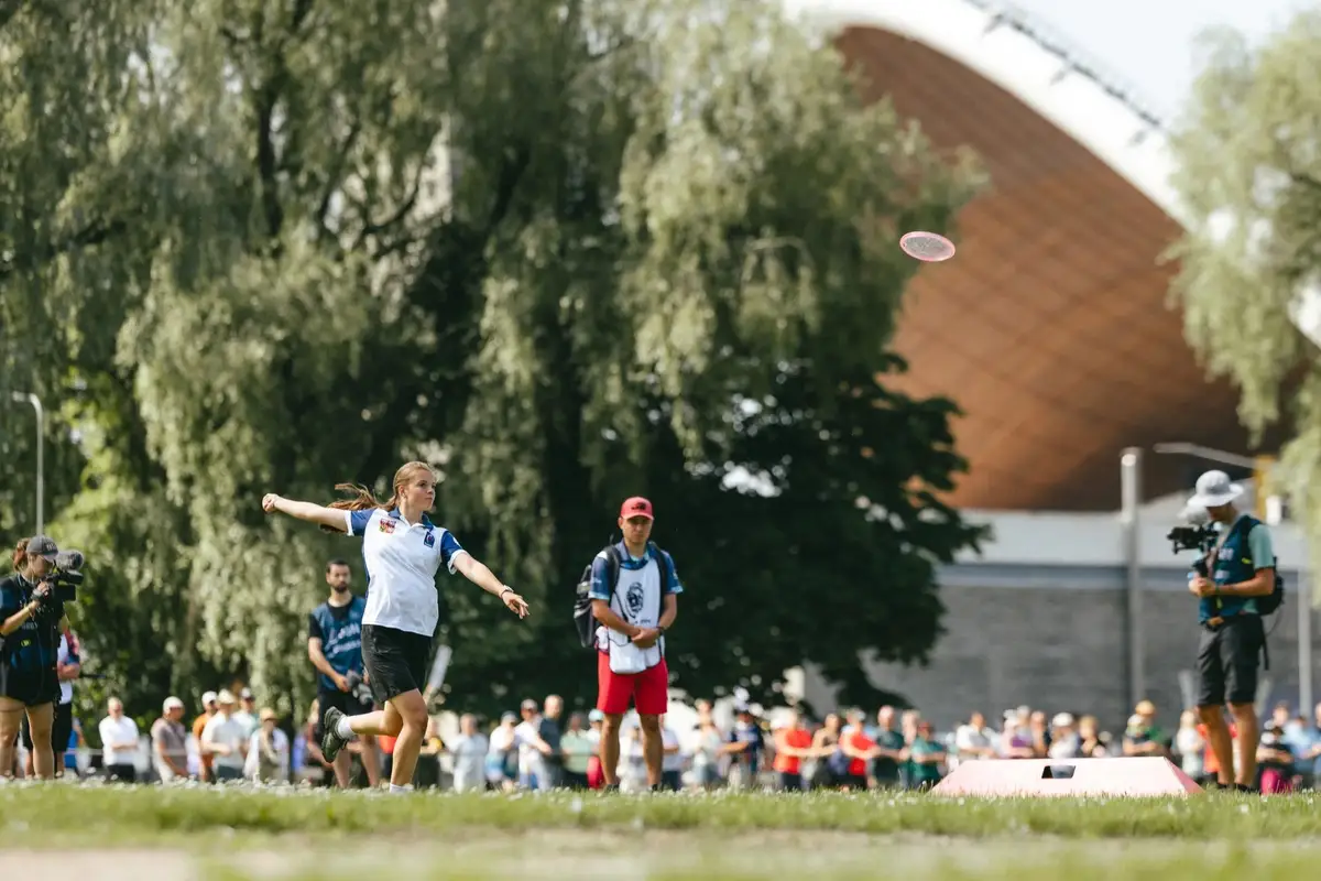 A player throwing in front of the Song Festival Grounds stage, the crowd behind